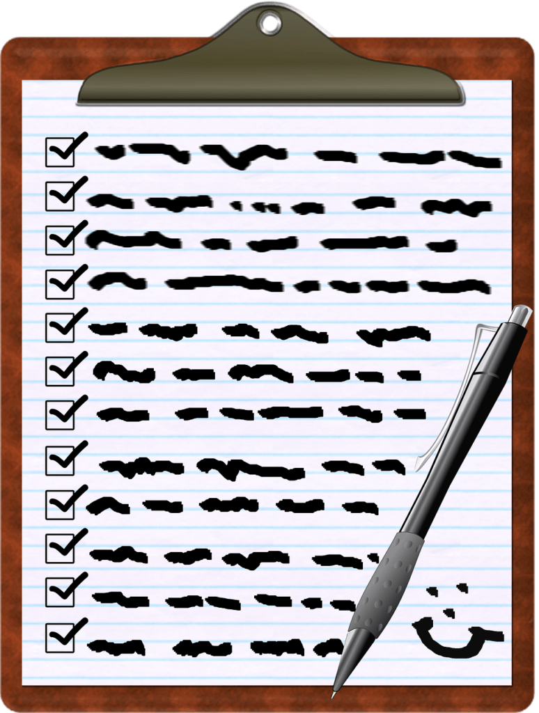 White paper containing a survey checklist on a brown clipboard. A silver pen is on top of it with a smiley.