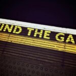 Bold 'Mind the Gap' text on a subway platform, emphasizing passenger safety.