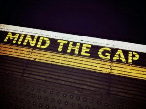Bold 'Mind the Gap' text on a subway platform, emphasizing passenger safety.