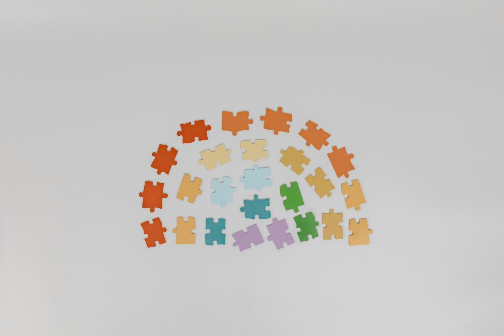 A collection of diverse colored puzzle pieces arranged on a white backdrop.